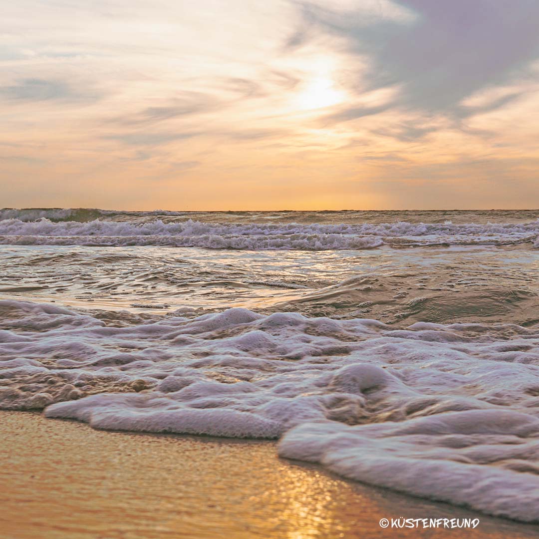 Ostseebild mit sanften Wellen und Sonnenuntergang